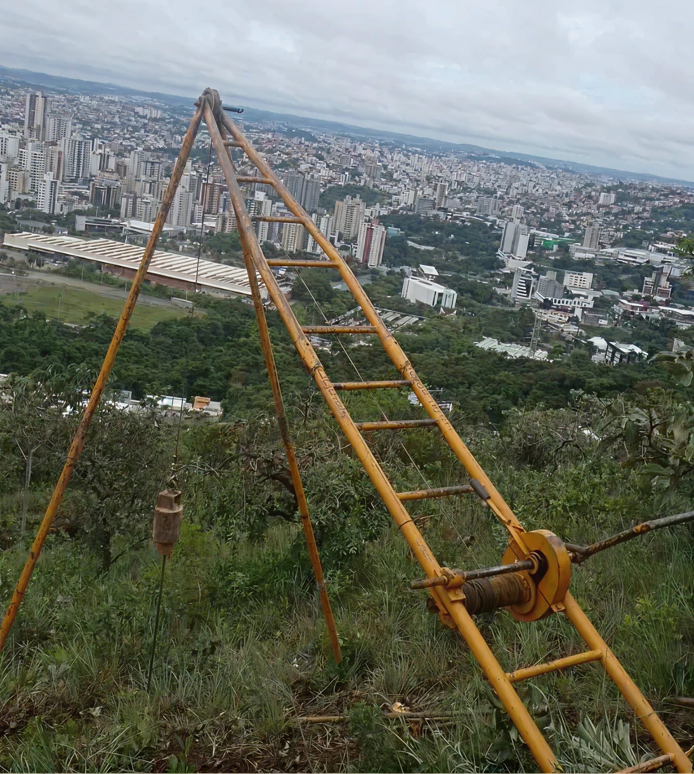 Tripé de sondagem em obra sobre a vista da cidade